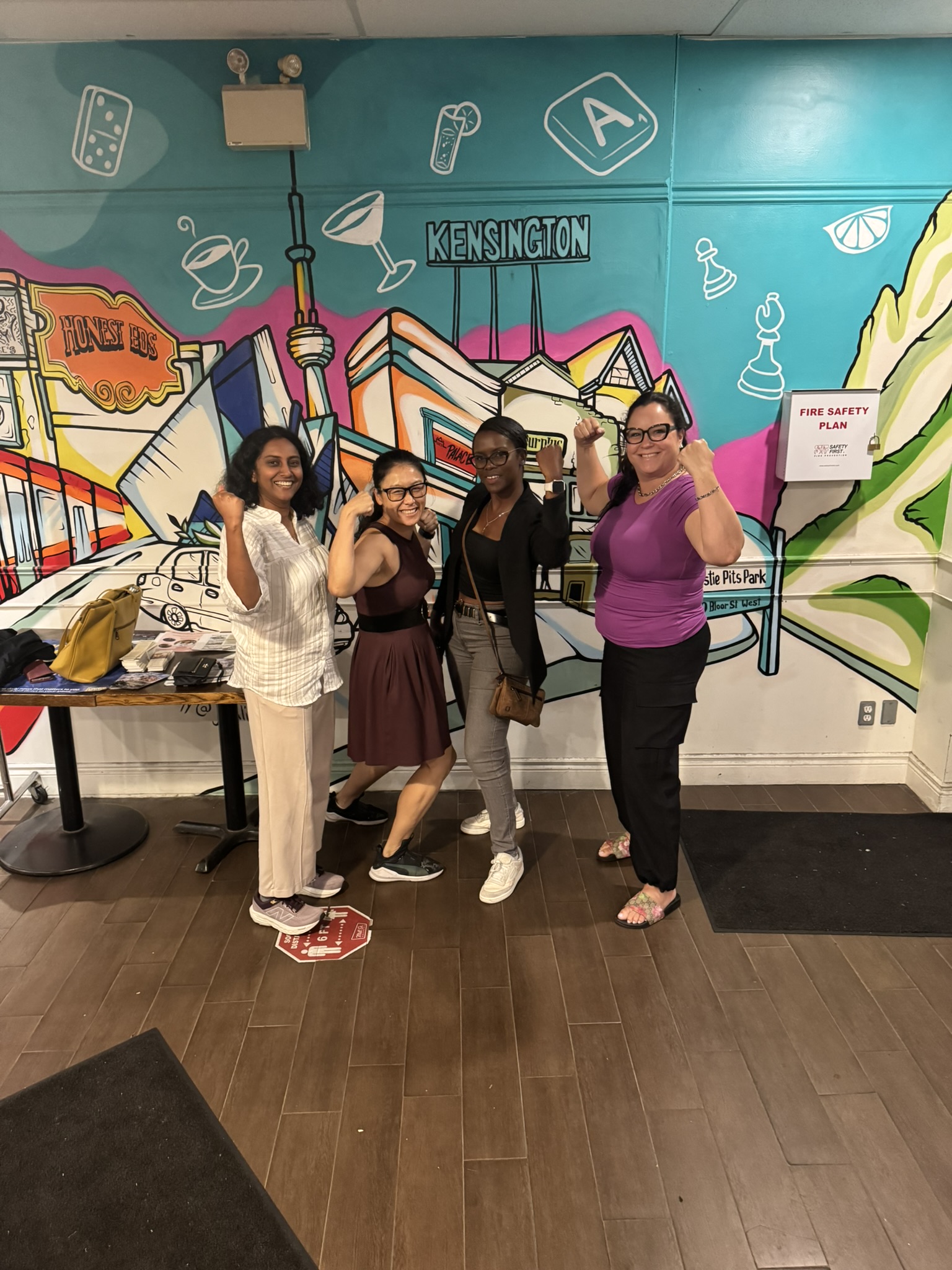 Four women celebrating and flexing after playing Game of Gains at a Toronto venue